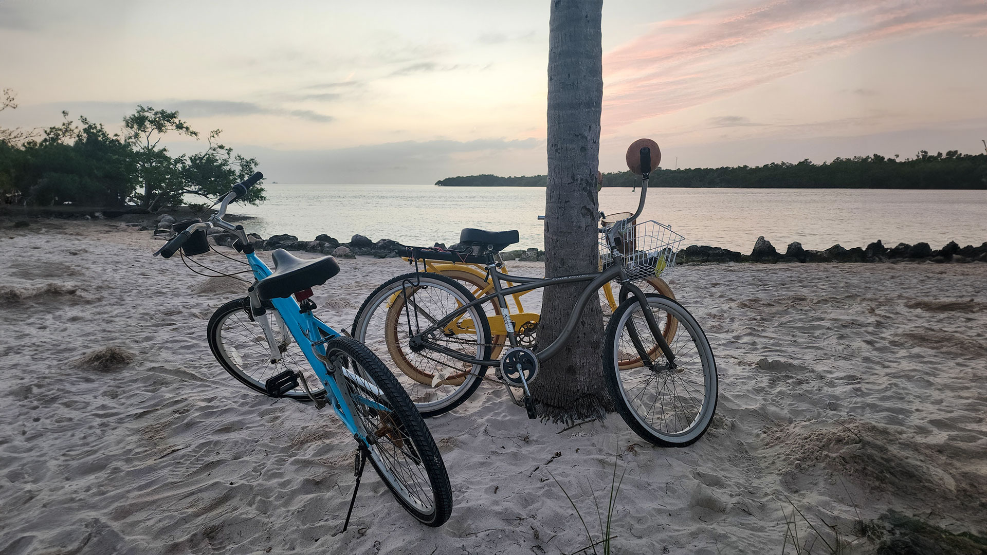 Two bicycles parked on the sandy shores of Sombrero Reef Beach in Marathon, Florida, provided as part of vacation rentals by Gulfview Getaways.